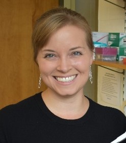 Kathleen Grogan smiling at the camera in a black shirt